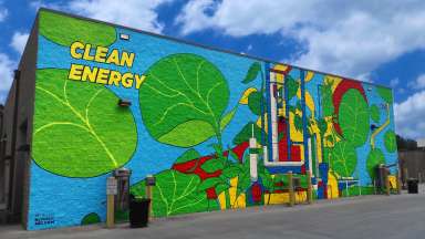 A colorful mural on a wall at Vehicle Fleet Services that reads Clean Energy