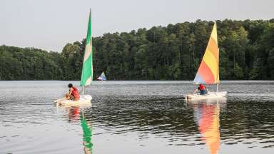 an image of two people sailing in the lake