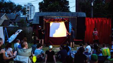 People gathered outside to watch an interactive shadow puppet show