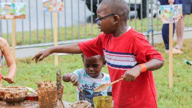 children using utensils to play with mud