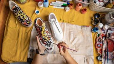 a person painting a sneaker with a paintbrush