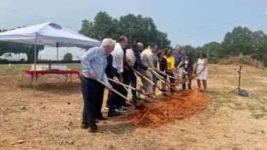 Developers, elected officials, and community members symbolically shoveling ground at Toulon Place