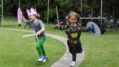 two children playing with crafted toy swords and shields