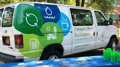 Raleigh's community engagement van next to table with information
