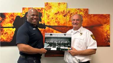 Chief Poole poses with Asst. Chief Griffin holding a photo of the RFD Class of 1978