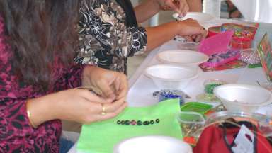 people using beads to make jewelry