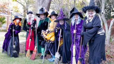 people dressed up as witches with brooms
