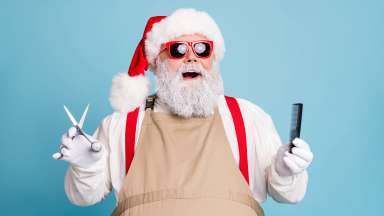 Santa with shades on holding scissors and a comb