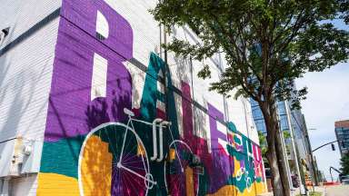 A vibrant mural featuring a bike that spells out Raleigh