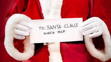 an image of santa holding a sing that says "to santa claus north pole"