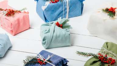 Gifts wrapped in holiday shrub garnish and reusable cloth.