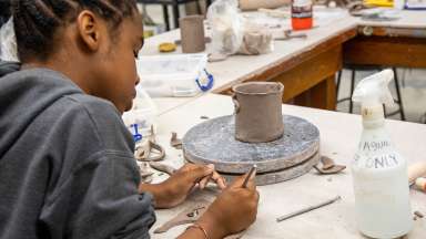 A teen works on a pottery piece during Artist Studio Summer Camp
