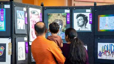 People viewing artwork hung on temporary panels