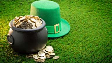 an image of a bot of gold and a leprechaun hat on a grassy area