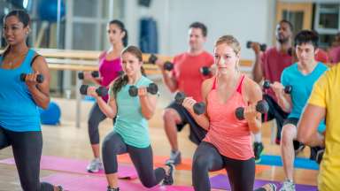 a group of adults working out together in a aerobic fitness class at the gym
