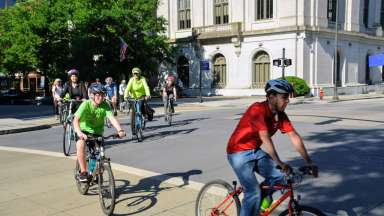 A group of people ride bikes in downtown Raleigh.