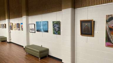 Several art pieces hang from the wall at Sertoma Art Center