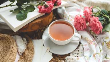Cup of hot tea, pink roses and spring home interior