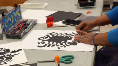 Woman's hands working on black and white abstract art