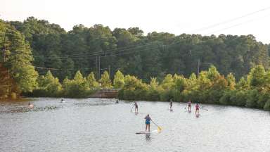 people on lake johnson on kayaks and stand up paddle boards