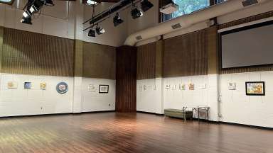 Gallery with small donut-themed artworks hung on the wall