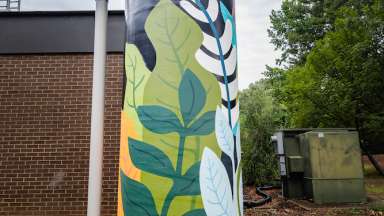 A vertical cistern painted with brightly colored plants.