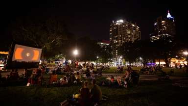 people watching a movie on the lawn at Moore square