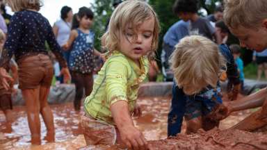 small children playing in the mud