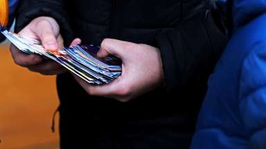 a hand holding a stack of trading cards