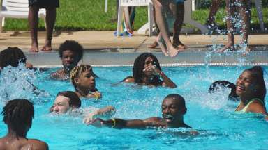 teens having fun splashing in the swimming pool