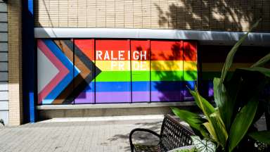 Raleigh pride flag painted on the side of a building