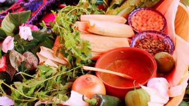 an image of tamales, peppers, toppings and sauce