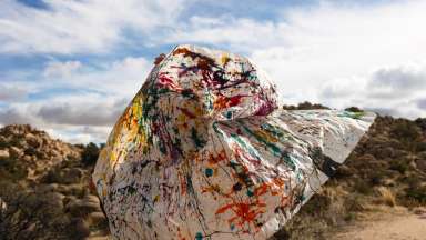 photograph of a large swath of white fabric splashed with paint.