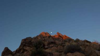 photograph of a moon rising over a hill/