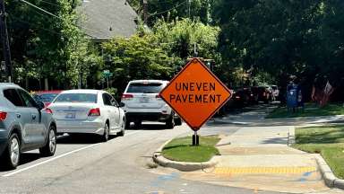 Image shows a section of Oberlin Road and the new sidewalk with signs that reads, uneven pavement