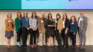 Sustainability staff hold a trophy