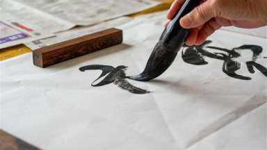 an image of someone painting a character on paper