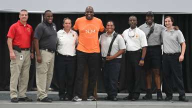 Members of the Raleigh Fire Department pose with former NBA player and coach Nate McMillan at the Nate McMillan Mentoring Camp.