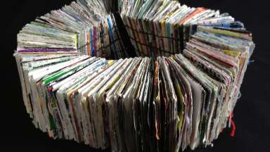 Book with handmade paper pages opening to a full circle.