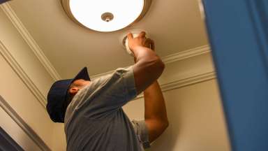 firefighter replacing a smoke detector