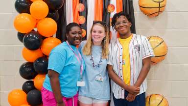 3 smiling young adults having fun while working