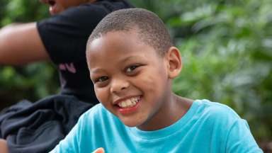 a smiling camper wearing a blue shirt