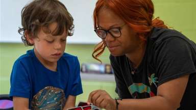 counselor and kid playing uno