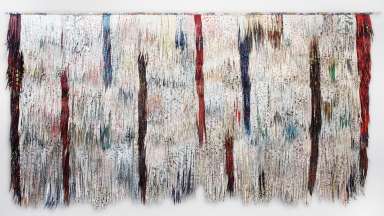 Fiber artwork with feathery white, red and blue marks.