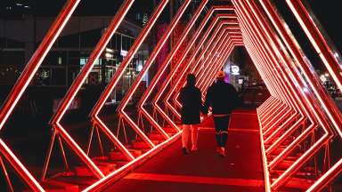 Geometric lights creating an orange tunnel.
