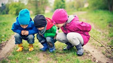 young children outside exploring findings on the ground