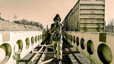 Art titled &quot;Derrick Davis&quot; Man walking in an industrial area by a train