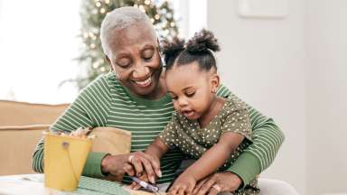 grandparent with child on lap doing crafts