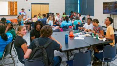 teens fellowshipping while enjoying pizza