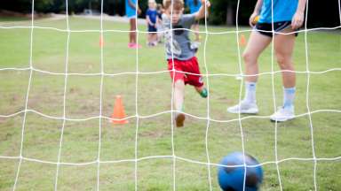 kid kicking a goal in soccer